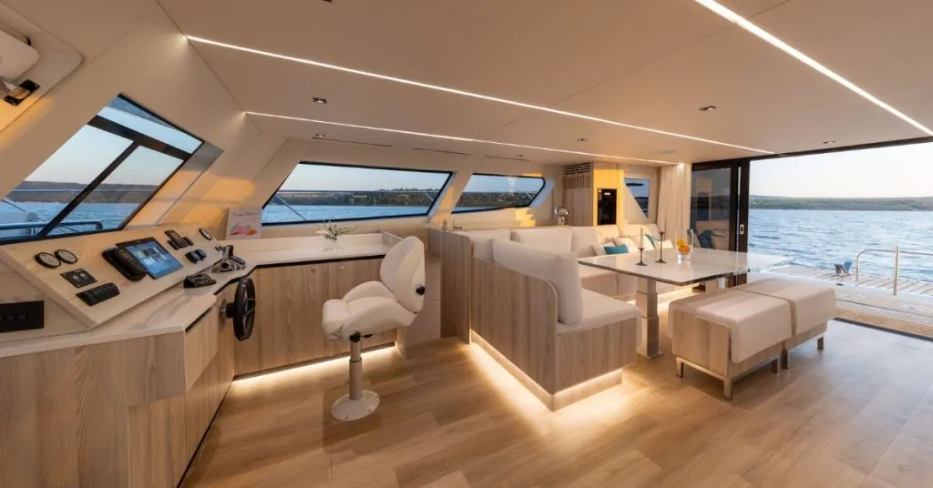 Diseño interior de catamarán a motor con salón panorámico y cocina abierta, ofreciendo 40% más espacio que un monocasco.